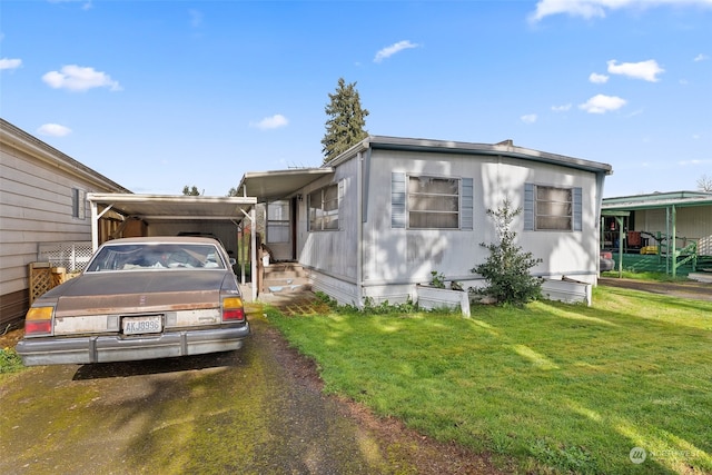 manufactured / mobile home with a front lawn and a carport