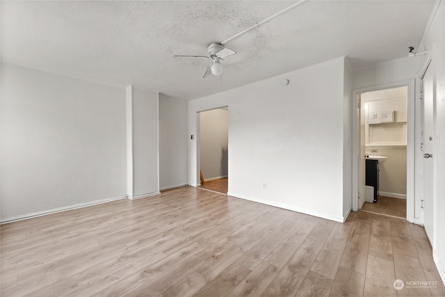 unfurnished room with ceiling fan, light hardwood / wood-style floors, and a textured ceiling