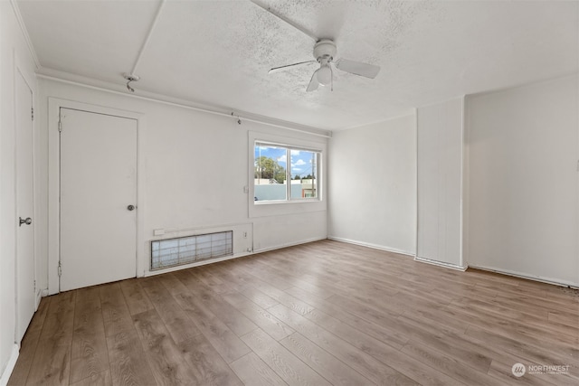 empty room featuring a textured ceiling, light hardwood / wood-style floors, and ceiling fan