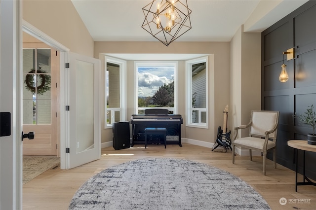 sitting room featuring a notable chandelier, light wood-type flooring, and french doors