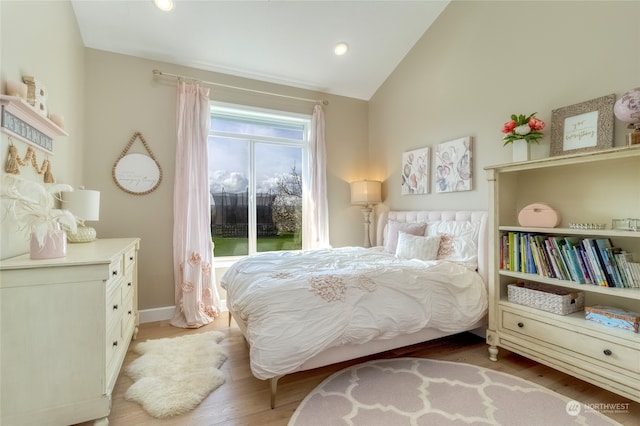 bedroom with vaulted ceiling, access to exterior, and light hardwood / wood-style flooring