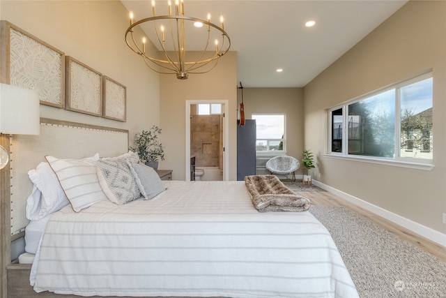 bedroom featuring hardwood / wood-style flooring, connected bathroom, and a notable chandelier