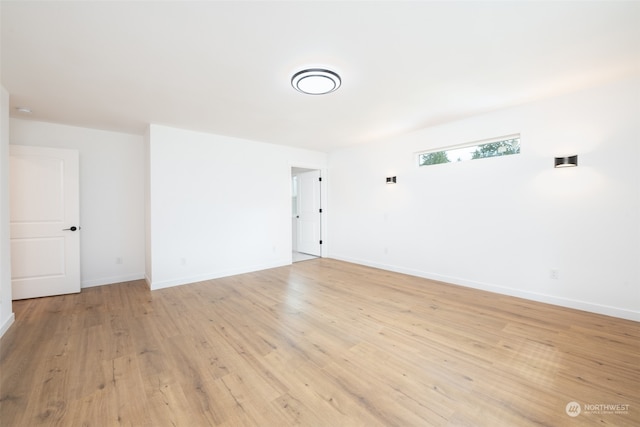 spare room featuring light wood-style flooring and baseboards