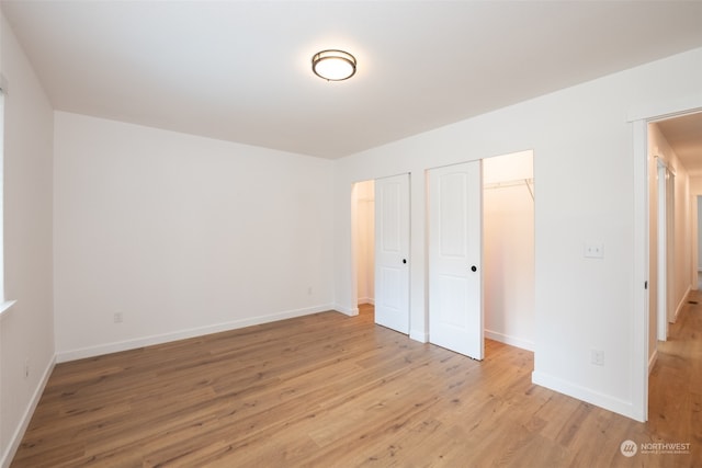 unfurnished bedroom featuring light wood-style flooring and baseboards