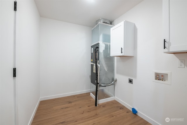 laundry room with hookup for a washing machine, light hardwood / wood-style floors, cabinets, and hookup for an electric dryer