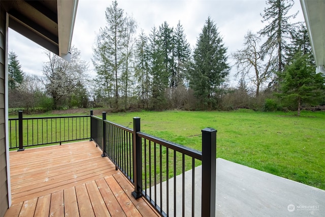 wooden terrace featuring a lawn