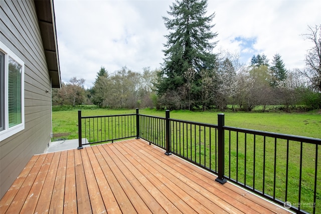 wooden terrace featuring a lawn