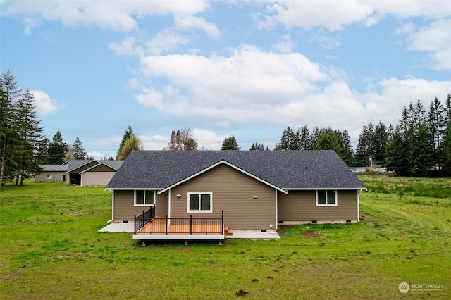 rear view of property featuring a shingled roof, crawl space, a wooden deck, and a lawn