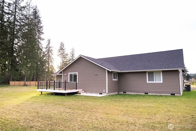 rear view of house featuring a deck, central AC, and a lawn