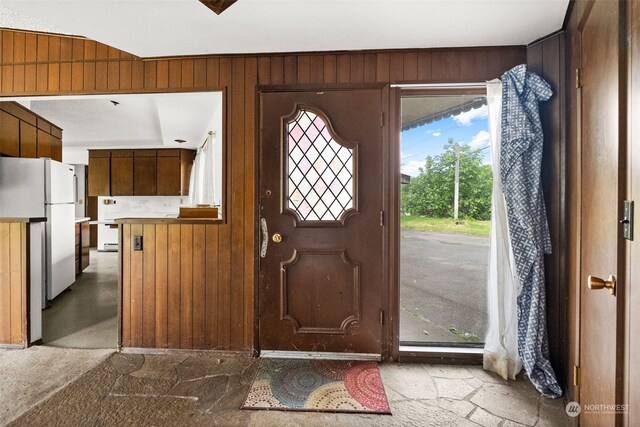 entryway featuring wooden walls