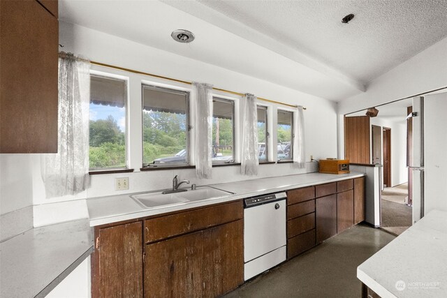 kitchen featuring dishwasher, sink, vaulted ceiling, a textured ceiling, and stainless steel refrigerator