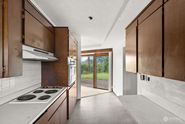 kitchen with a textured ceiling, backsplash, oven, and white stovetop