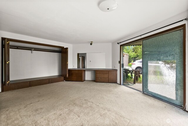 unfurnished bedroom with light carpet and access to outside