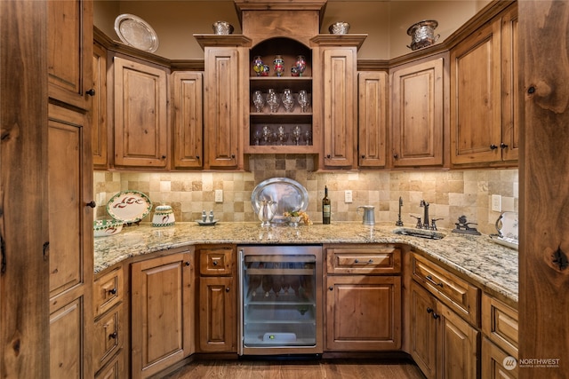 kitchen with light stone countertops, sink, beverage cooler, tasteful backsplash, and dark hardwood / wood-style flooring