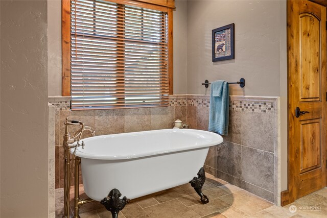 bathroom featuring tile patterned flooring, tile walls, and a tub