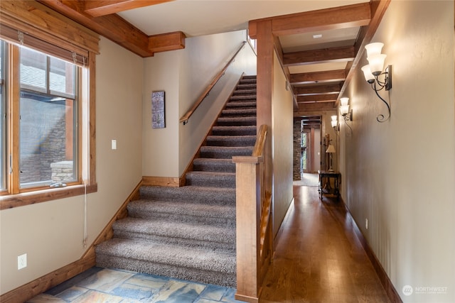 stairway with beam ceiling and wood-type flooring