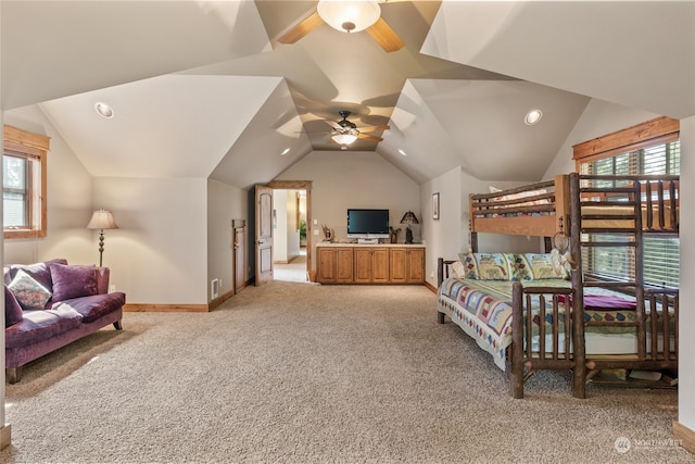 carpeted bedroom with multiple windows, ceiling fan, and vaulted ceiling