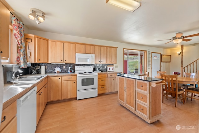 kitchen featuring a center island, white appliances, light hardwood / wood-style flooring, sink, and ceiling fan