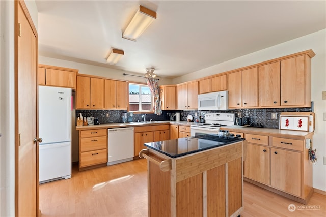 kitchen with white appliances, light hardwood / wood-style flooring, light brown cabinets, backsplash, and a kitchen island