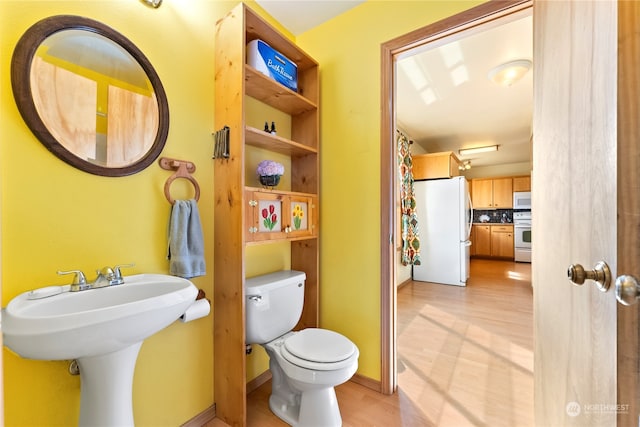 bathroom with hardwood / wood-style floors and toilet