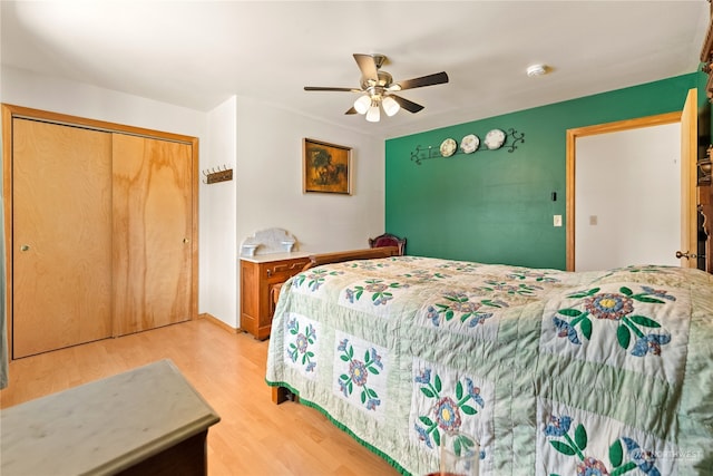 bedroom with light hardwood / wood-style flooring, ceiling fan, and a closet