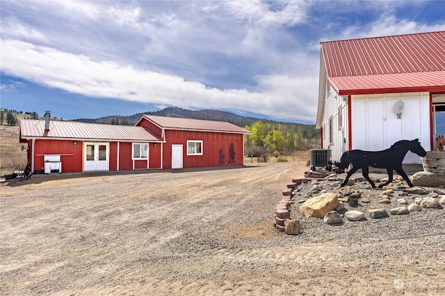 view of yard featuring a mountain view, an outdoor structure, and central AC unit