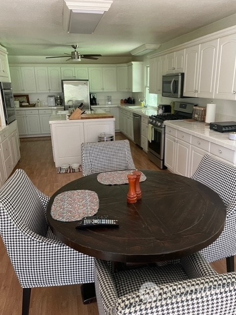 dining room with ceiling fan, dark hardwood / wood-style floors, and sink