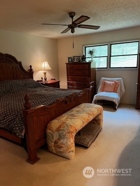 bedroom featuring a textured ceiling, ceiling fan, and carpet floors