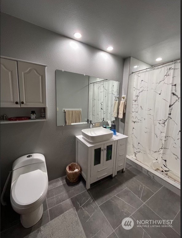 bathroom featuring tile flooring, toilet, and large vanity