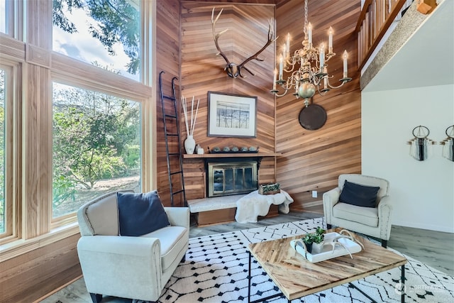 living room featuring a wealth of natural light, a towering ceiling, and a chandelier