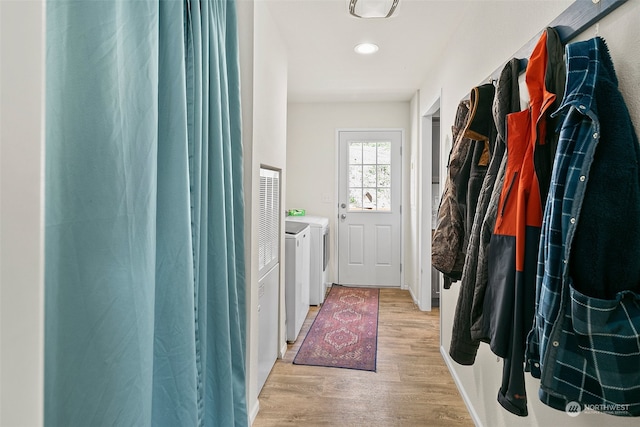 interior space with washing machine and dryer and light hardwood / wood-style flooring