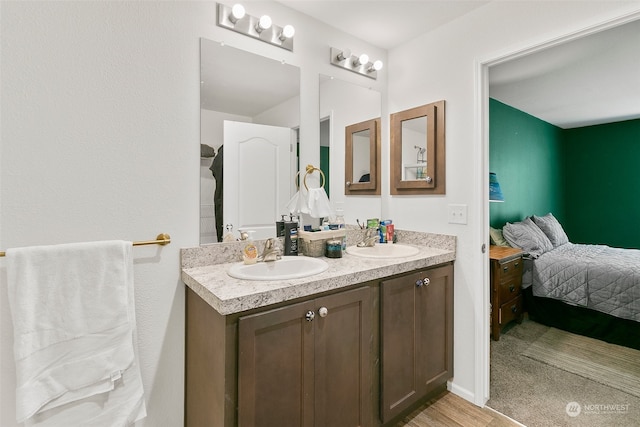 bathroom with dual sinks, hardwood / wood-style flooring, and large vanity