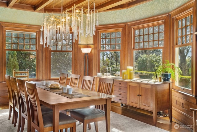 dining room with beamed ceiling, a chandelier, and hardwood / wood-style floors