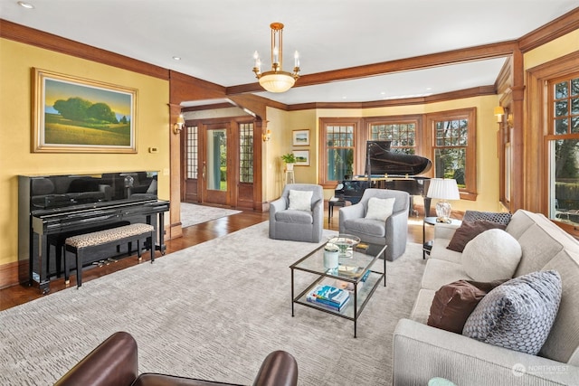 living room with crown molding, hardwood / wood-style floors, and an inviting chandelier