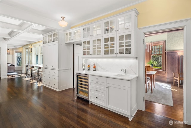 kitchen with beverage cooler, plenty of natural light, and white cabinetry