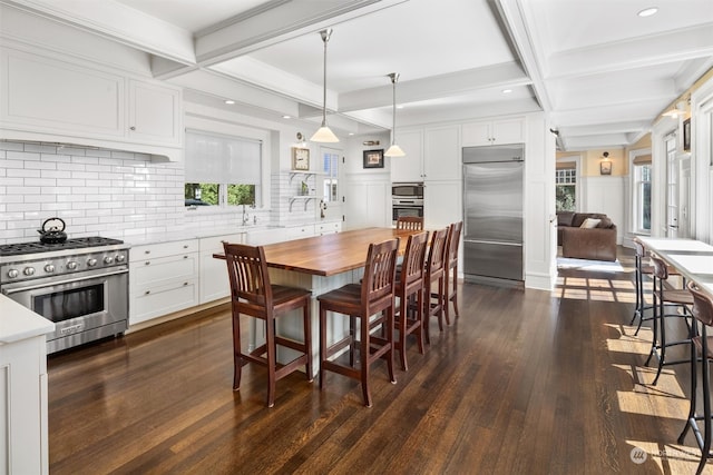 dining space featuring beam ceiling, dark hardwood / wood-style flooring, and a wealth of natural light