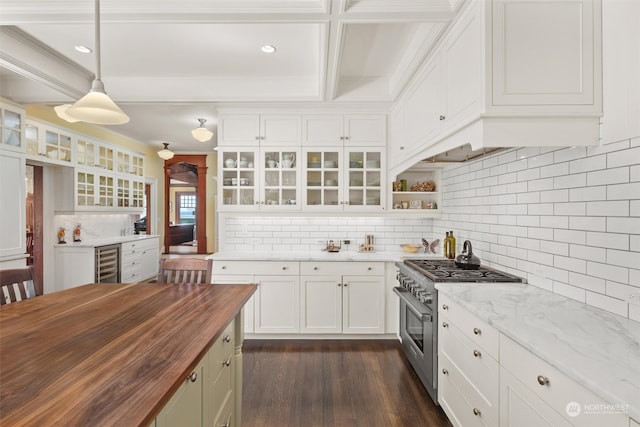 kitchen featuring high end range, pendant lighting, beverage cooler, butcher block counters, and white cabinets