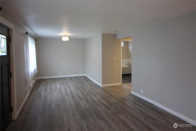 unfurnished room with dark hardwood / wood-style flooring