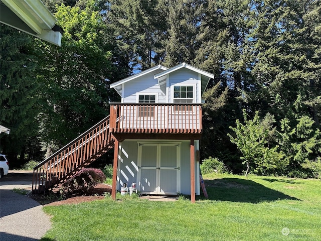 view of front property with a storage shed, a deck, and a front yard