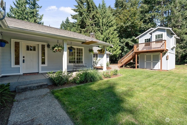 view of front of house with covered porch, stairs, a front yard, and roof with shingles