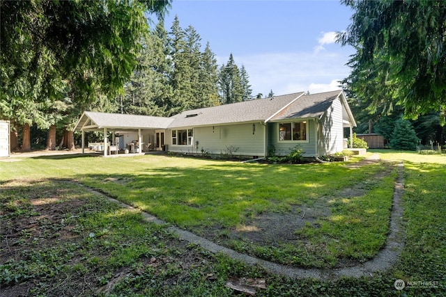 rear view of house featuring a yard