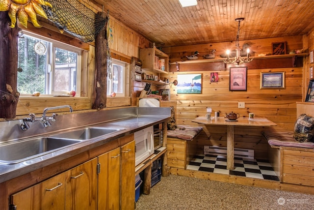 kitchen featuring pendant lighting, wooden walls, sink, and wooden ceiling