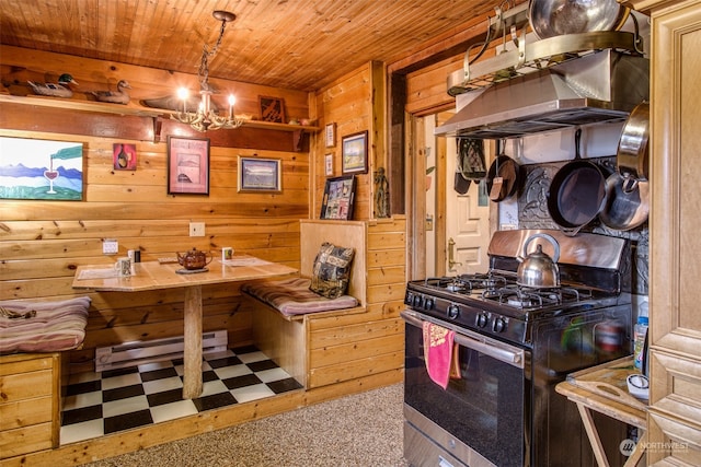 kitchen with wood ceiling, ventilation hood, gas range, a baseboard radiator, and wood walls