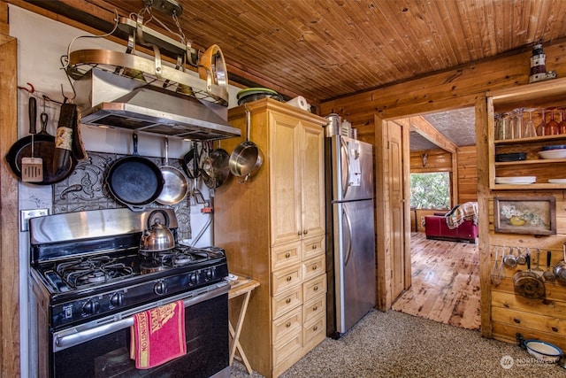 kitchen featuring carpet flooring, wooden walls, light brown cabinets, and appliances with stainless steel finishes