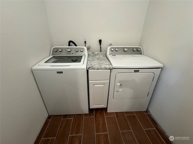 washroom featuring washing machine and dryer, wood-type flooring, electric dryer hookup, and cabinets