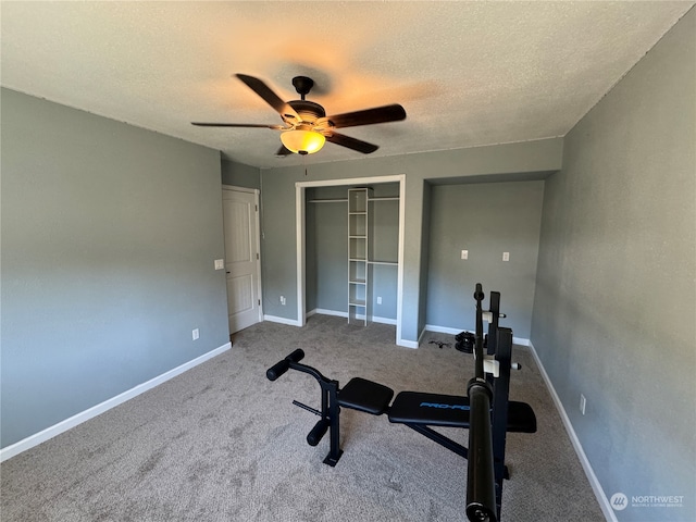 exercise room with ceiling fan, carpet flooring, and a textured ceiling