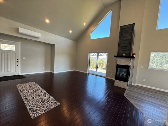 living room with high vaulted ceiling, a wall mounted air conditioner, and dark wood-type flooring