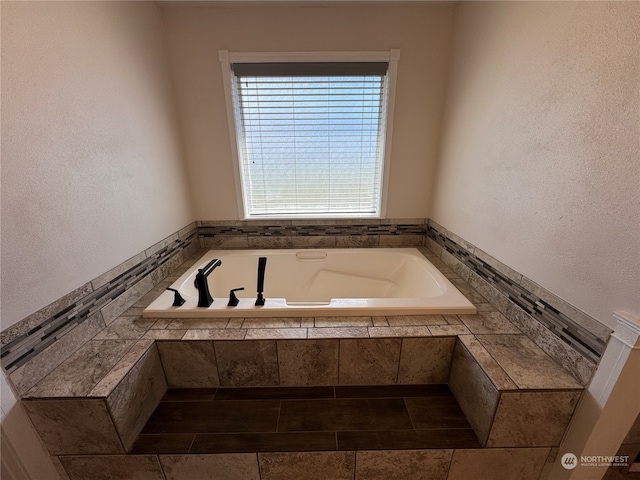 bathroom with a relaxing tiled bath