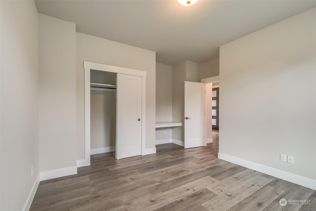 unfurnished bedroom featuring hardwood / wood-style flooring and a closet