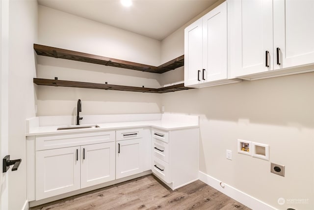 laundry area featuring sink, cabinets, washer hookup, hookup for an electric dryer, and light hardwood / wood-style flooring